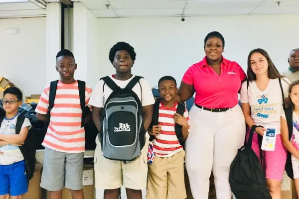 AFSCME Florida President Vicki Hall with Miami students receiving new pack packs and supplies